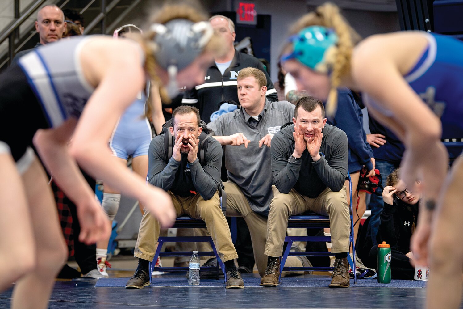 Quakertown’s coaching staff shouts out instructions during Ashley Stank’s 106-pound match.