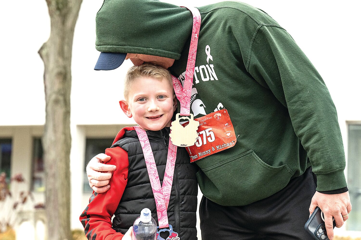 Chris Bullick, of Warminster, rewards his son, Michael Bullick, with a kiss following the completion of the Great Cupid Run.