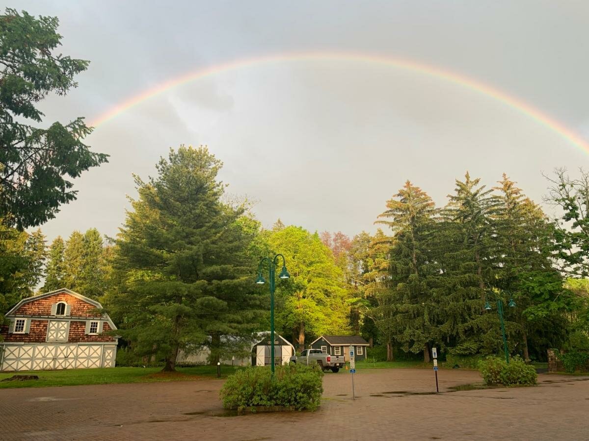 A rainbow encompasses the carriage barn at the Johnson Education Center.