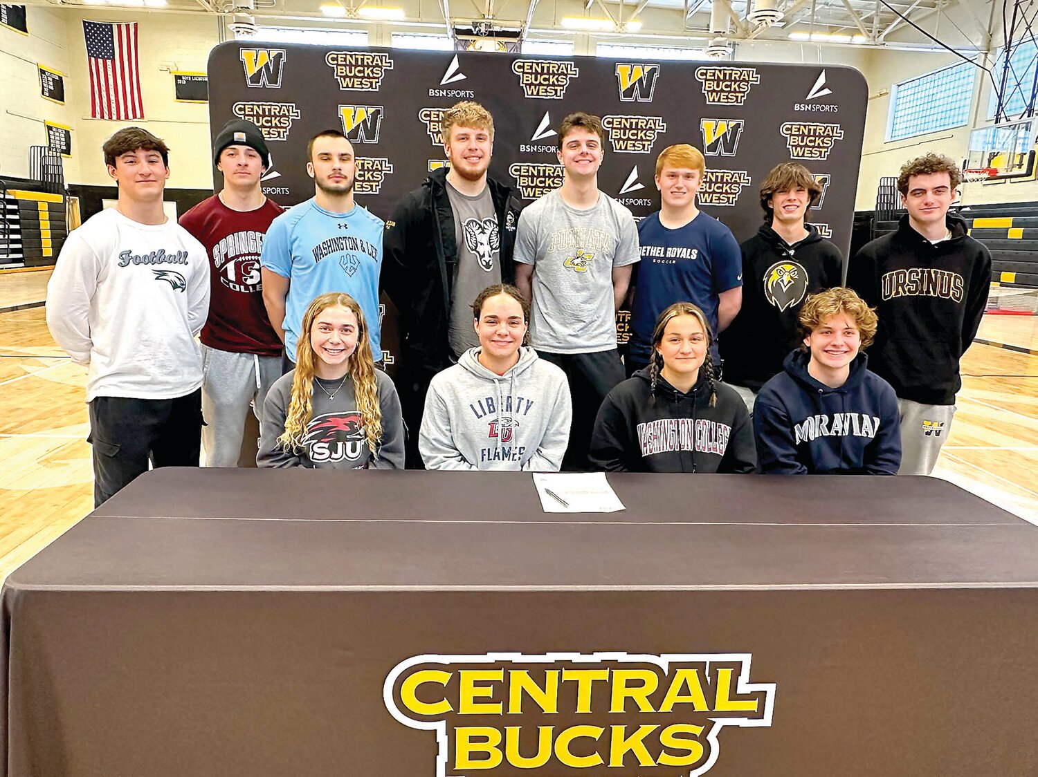 Central Bucks West recognized 12 seniors for their commitment to compete in collegiate sports. From left are: front row, Madelynn Massey, Abby Rogers, Molly Gross, Jackson Lombardi; standing, Jaden Barone, Jack Fleisher, Cooper Taylor, Hayden Mulligan, Bowen Gugger, Griffin Blokker, Richard Newell and Cayden Wertz.