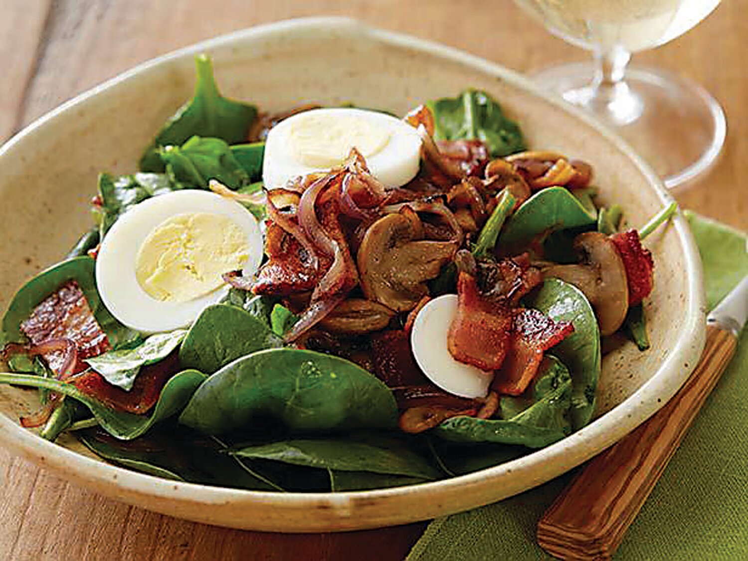 Warm dressing on a spinach salad makes a cold salad into a warm dish.