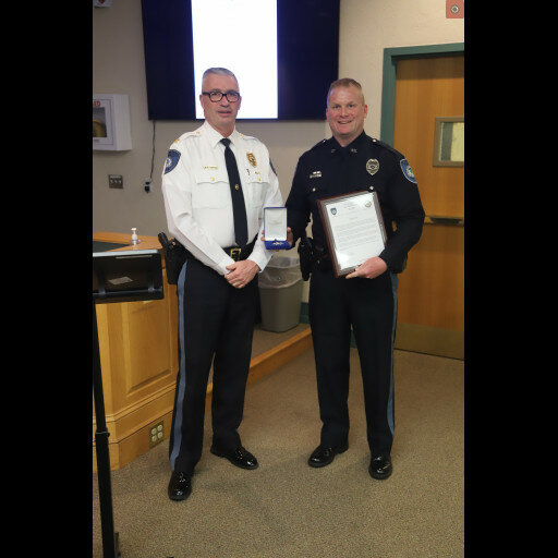 Standing beside Plumstead Township Police Chief David Mettin, left, is Officer Thomas J. Rutecki, holding his Police Star, awarded March 13, for his heroic actions.