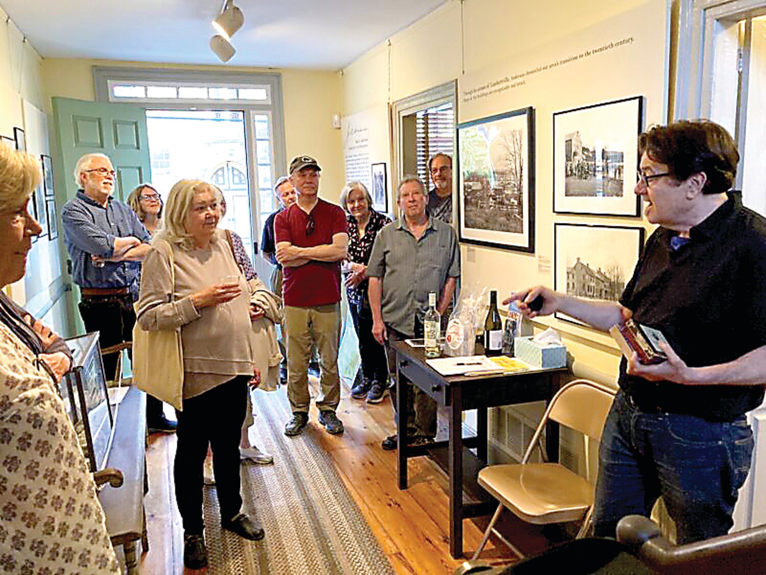 Stephen Harris (far right) and Jeffrey Apoian, (near right) speak with guests touring the Marshall House Museum exhibit on Lambertville photographer John A. Anderson, curated by Michael Menche, Apoian, Harris, and an LHS team of volunteers.