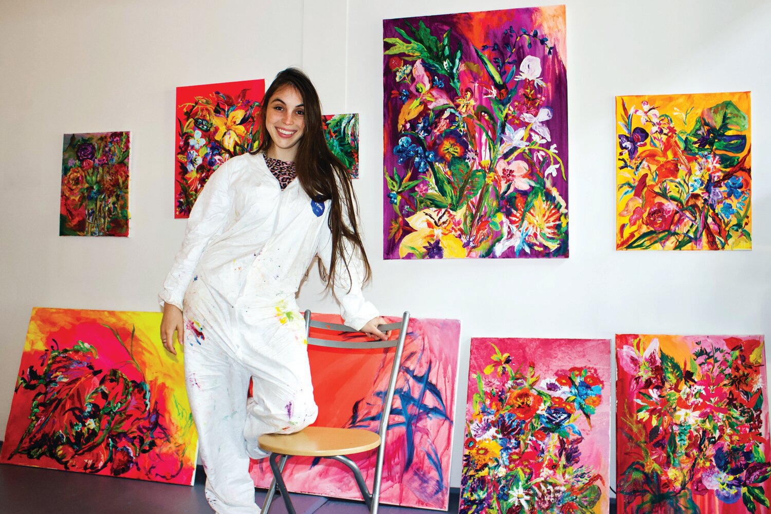 Bucks County artist Caroline Stoughton pauses in her studio, with some of her colorful paintings.
