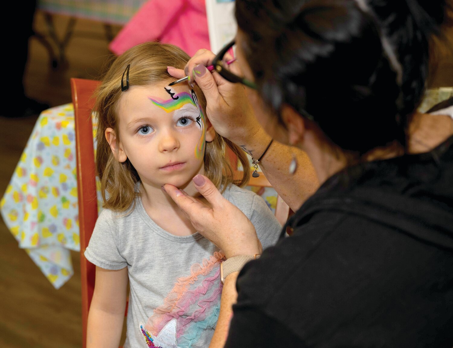 Zofia Cendrowski gets a unicorn added to her face by painter Liza Schuck.