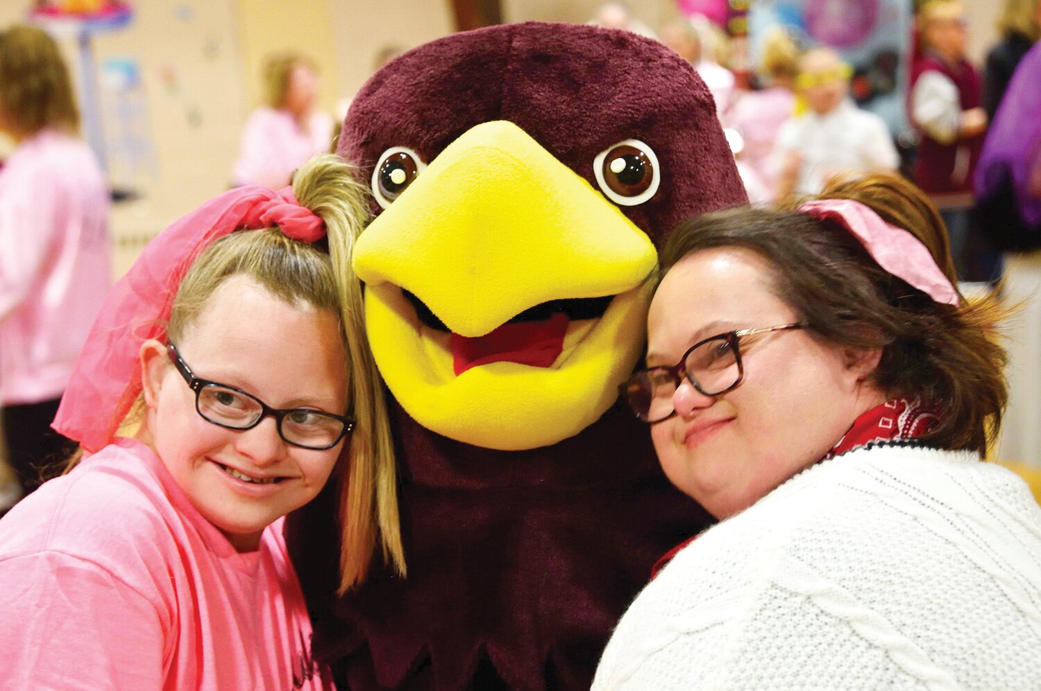 Julia Shirey and Abby Plummer greet Hawk, the St. Joseph/St. Robert mascot played by eighth grader Ashley Stefanik.