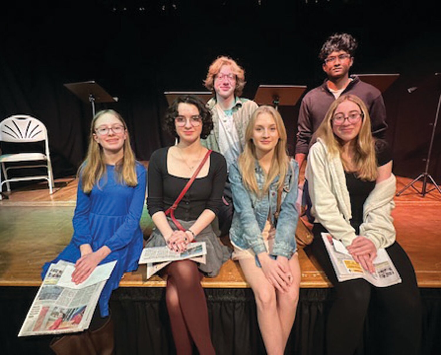 Winners of the “Play With Words” playwriting challenge sit at the edge of the stage at Phillips’ Mill. From left are: Front row, Corinne Brintnall, Saskia Cooper, Matilda Bray, Avigain Vus: Back row, Finn Anderson, Srikar Pothuraju.
