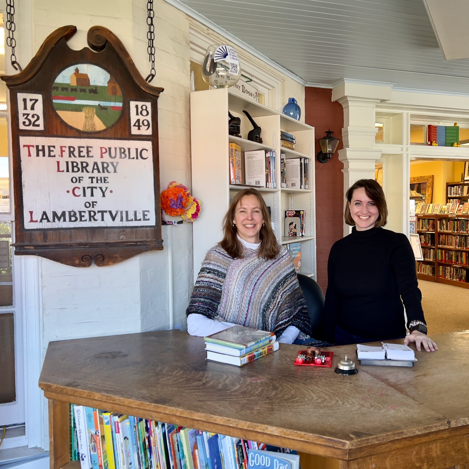 Lambertville Library Director Jennifer Sirak and Head of Youth Services Danielle Bey stand at the front desk.