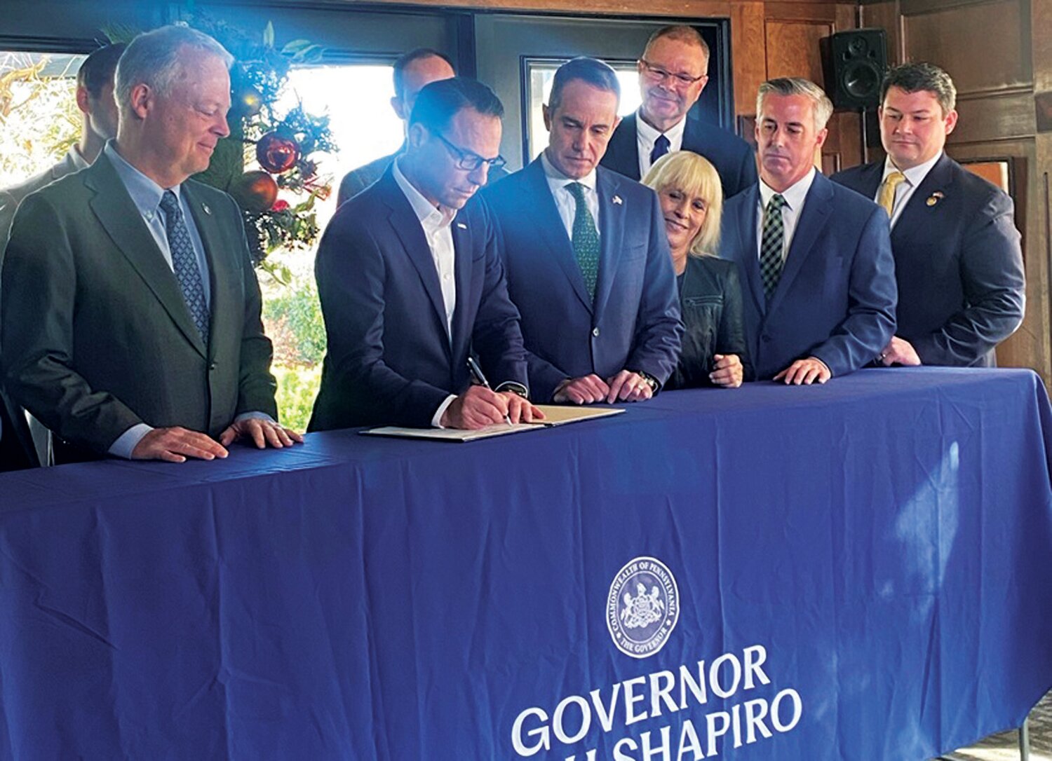 Flanked by Rep. Perry Warren, left, and Pa. Sen. Steve Santarsiero, right, Pennsylvania Governor Josh Shapiro signs House Bill 735 in late 2023 at The Yardley Inn. HB 735 creates the Flood Insurance Premium Assistance Task Force.