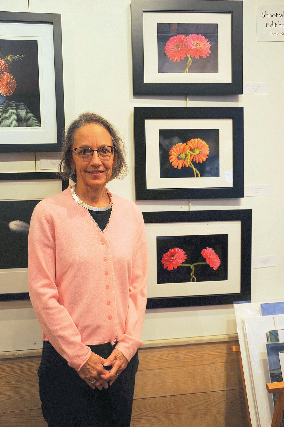Anita Bhala standing next to her Zinnia photographs. “Turning” won the Abstract Award.