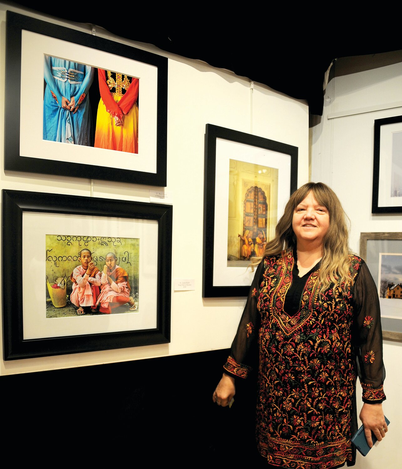 Linda Heath stands beside two of her photographs. One – “Housemaids in India” – won the Street Award.