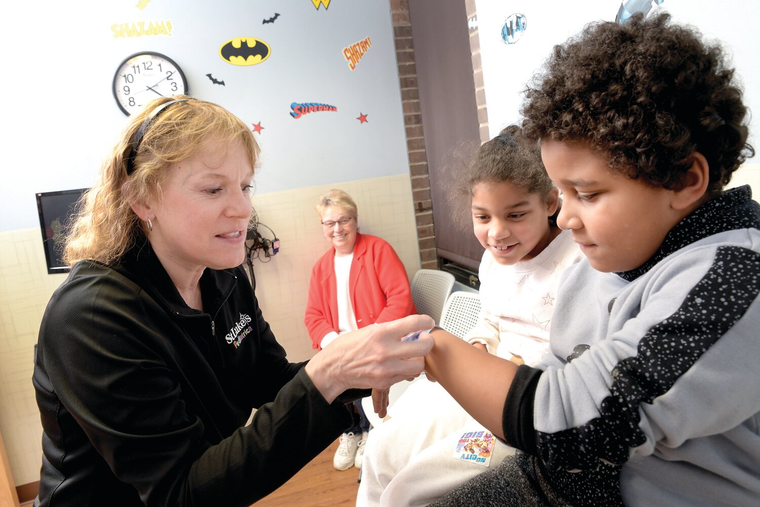 Grandmother Robin Geiger watches as case manager Terry Gregg, registered nurse, talks with her twin grandchildren, Sunny and Tizlam Gordon, at Star Community Health Pediatrics in Easton.