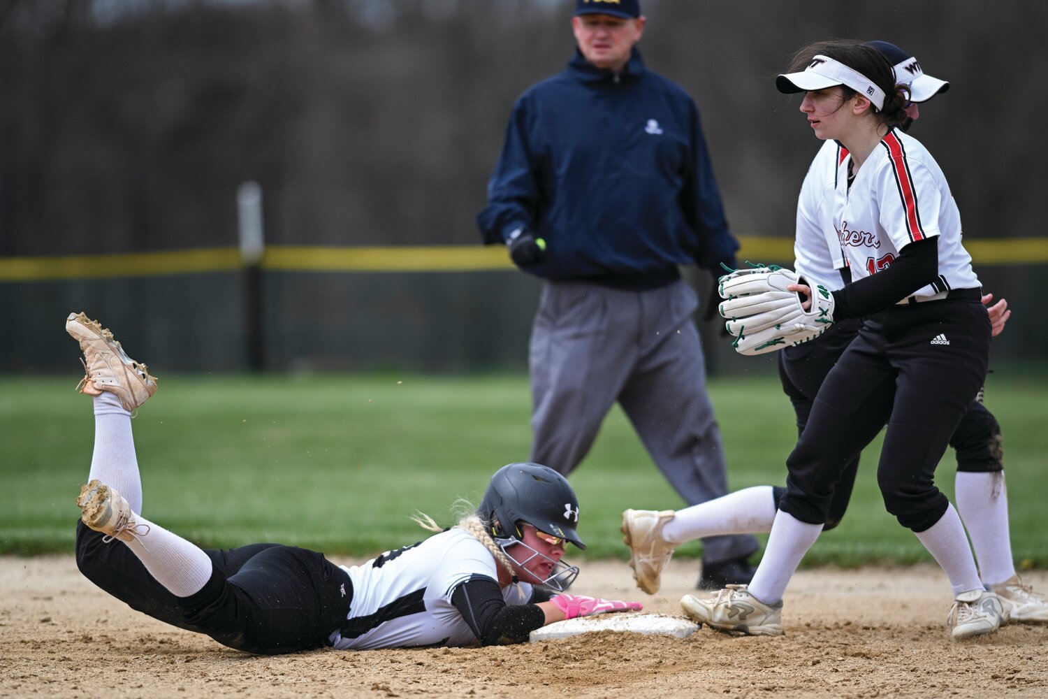 Archbishop Wood’s Allison Siegfried successfully dives back to second after avoiding a double play in the third inning.