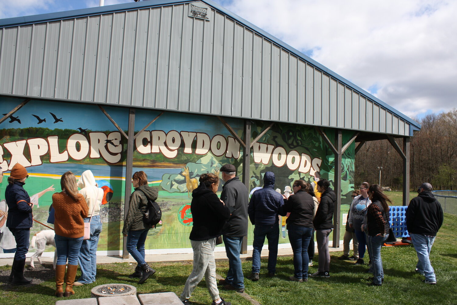 Students and stakeholders view the “Explore Croydon Woods” mural at the 80-acre nature preserve in Bristol Township when the idyllic image was unveiled earlier this month.