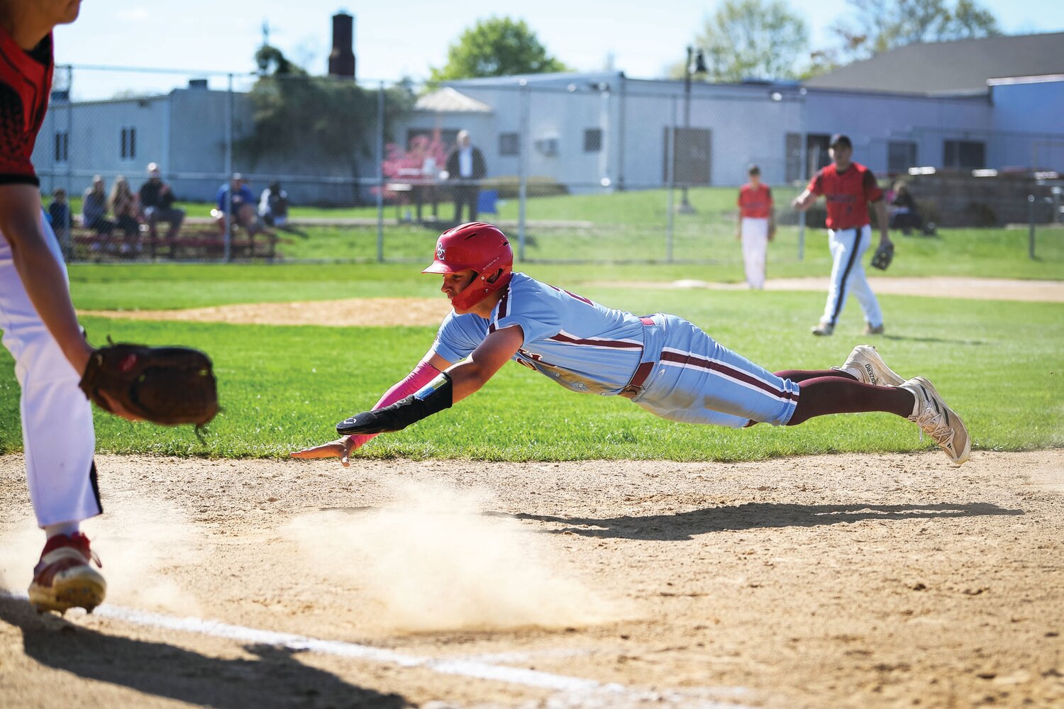 Faith Christian’s Brandon Labs dives back into first base and avoids a double play after a short fly to center in the third inning.