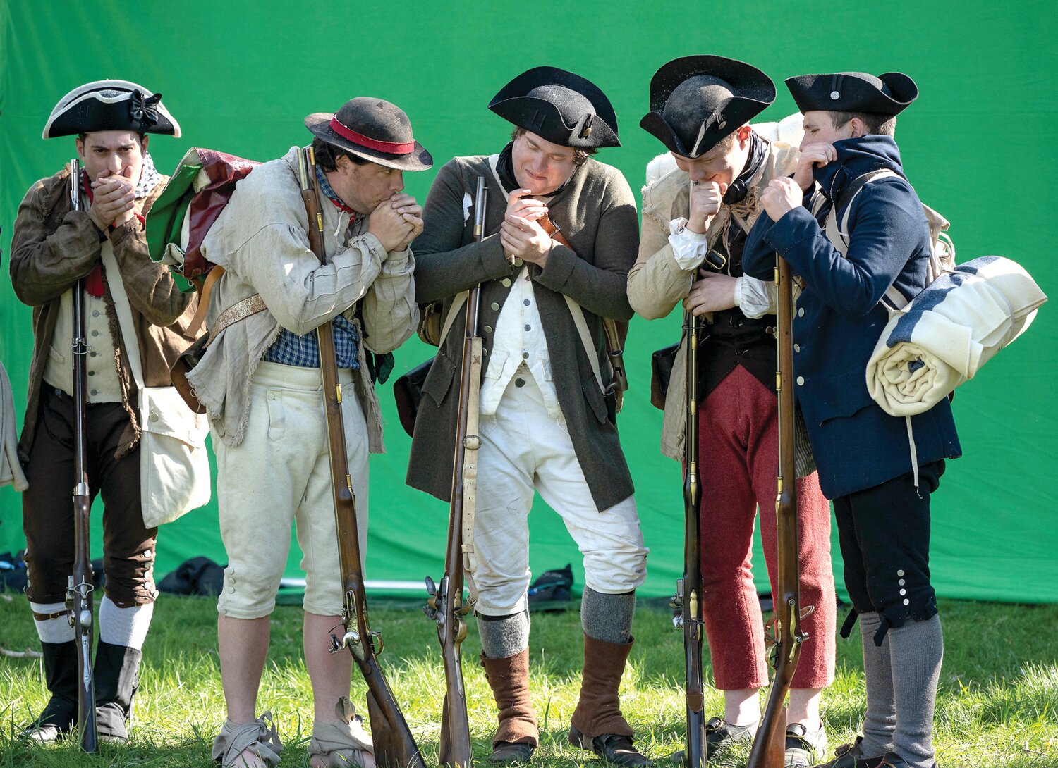 Actors try to look cold while filming a winter scene in front of a green screen on a mild mid-April afternoon at Washington Crossing Historic Park.