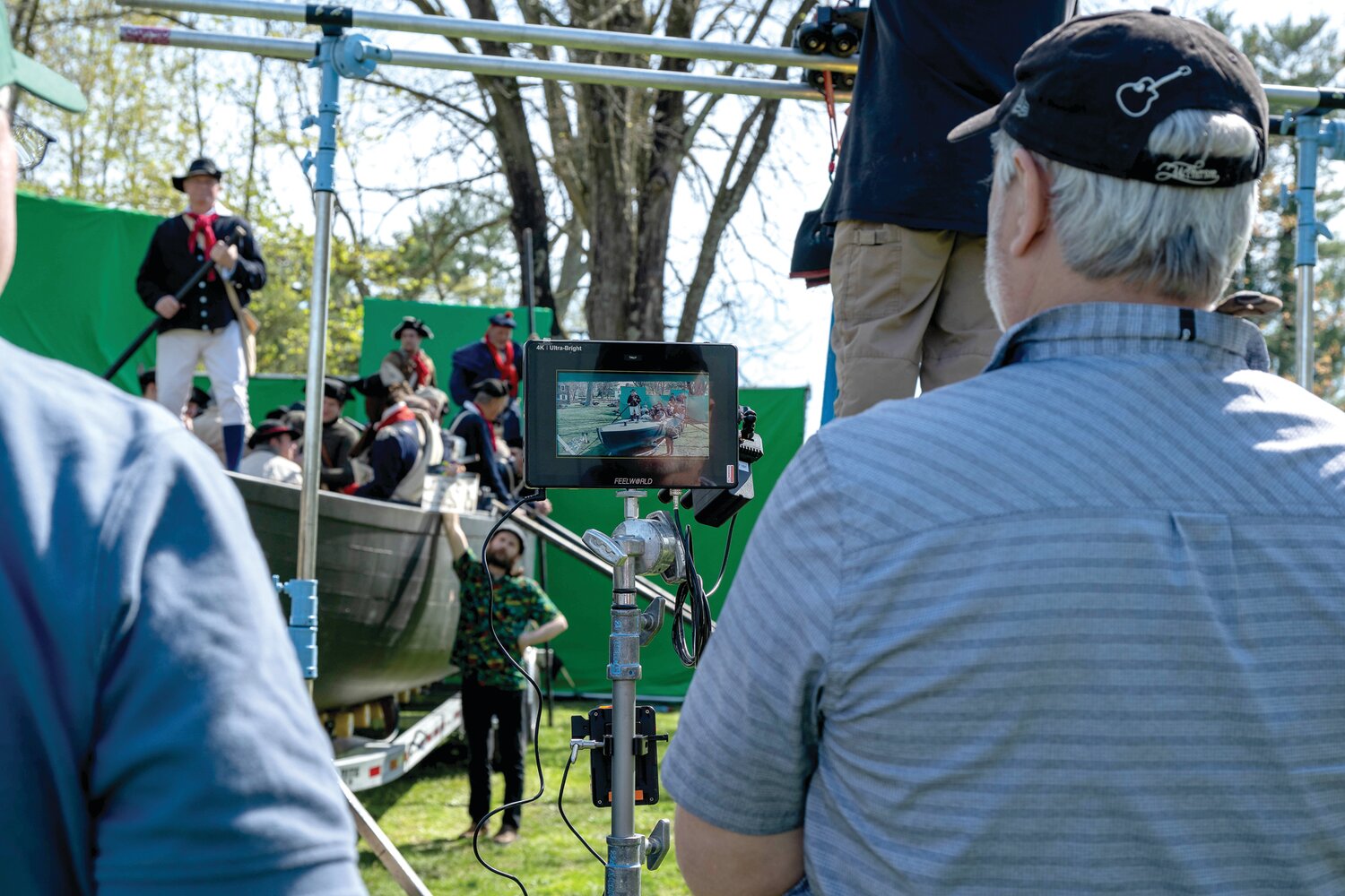 The reenactors shoot a river crossing scene in front of green screens. The river will be digitally added later.