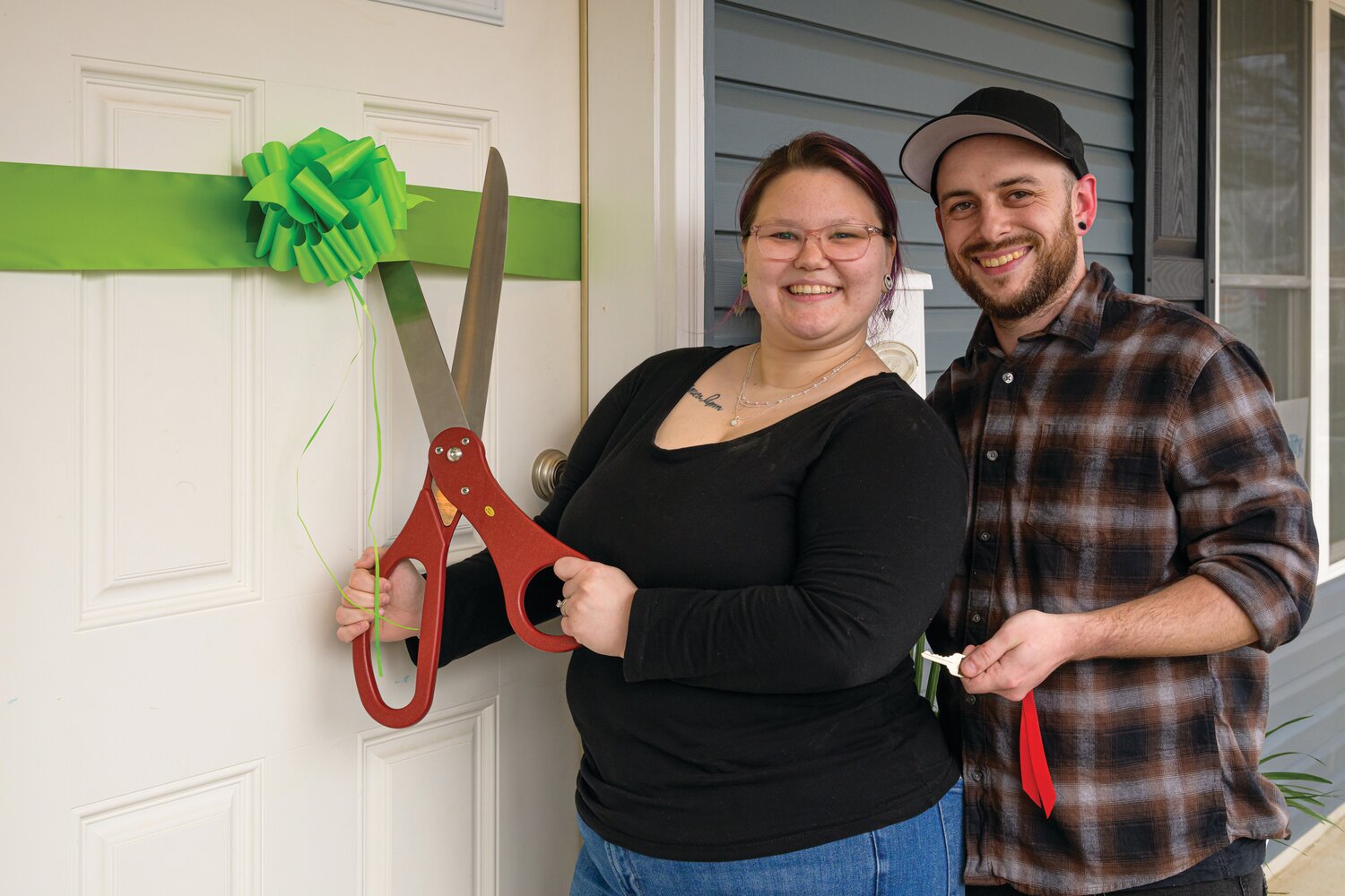 Tyler and Angelica cut the ceremonial ribbon on their new home in Croydon, the fruits of their work in the Homeownership Program of Habitat for Humanity Bucks County.