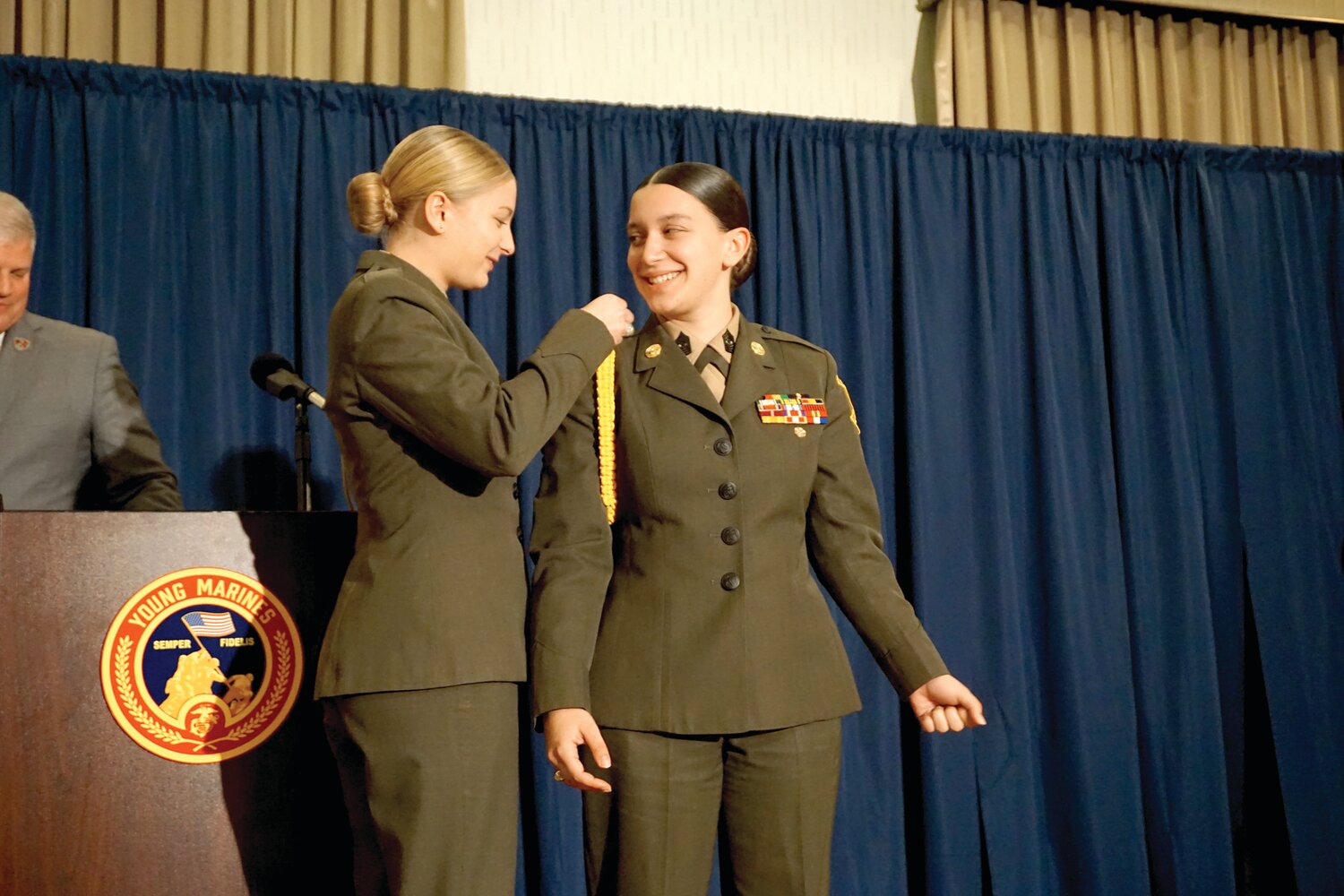 Susan Suber of Pipersville receives the ceremonial gold braid signifying the beginning of her year as National Young Marine of the Year from outgoing 2023 winner, Isabel Benson of Lapeer County Young Marines in Lapeer, Mich.
