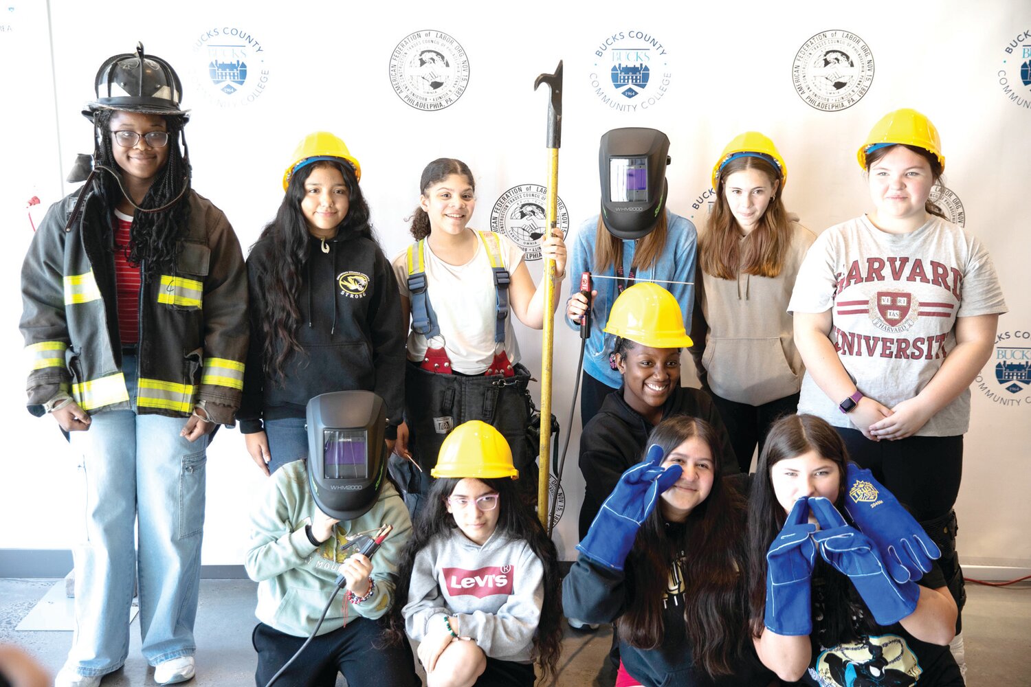 Female middle school students from Bristol Township School District representing various building and construction trades as well as emergency responders pose for a group photo during Girls Ignite, a one-day career expo made possible by the Philadelphia Building & Construction Council and Bucks County Community College.