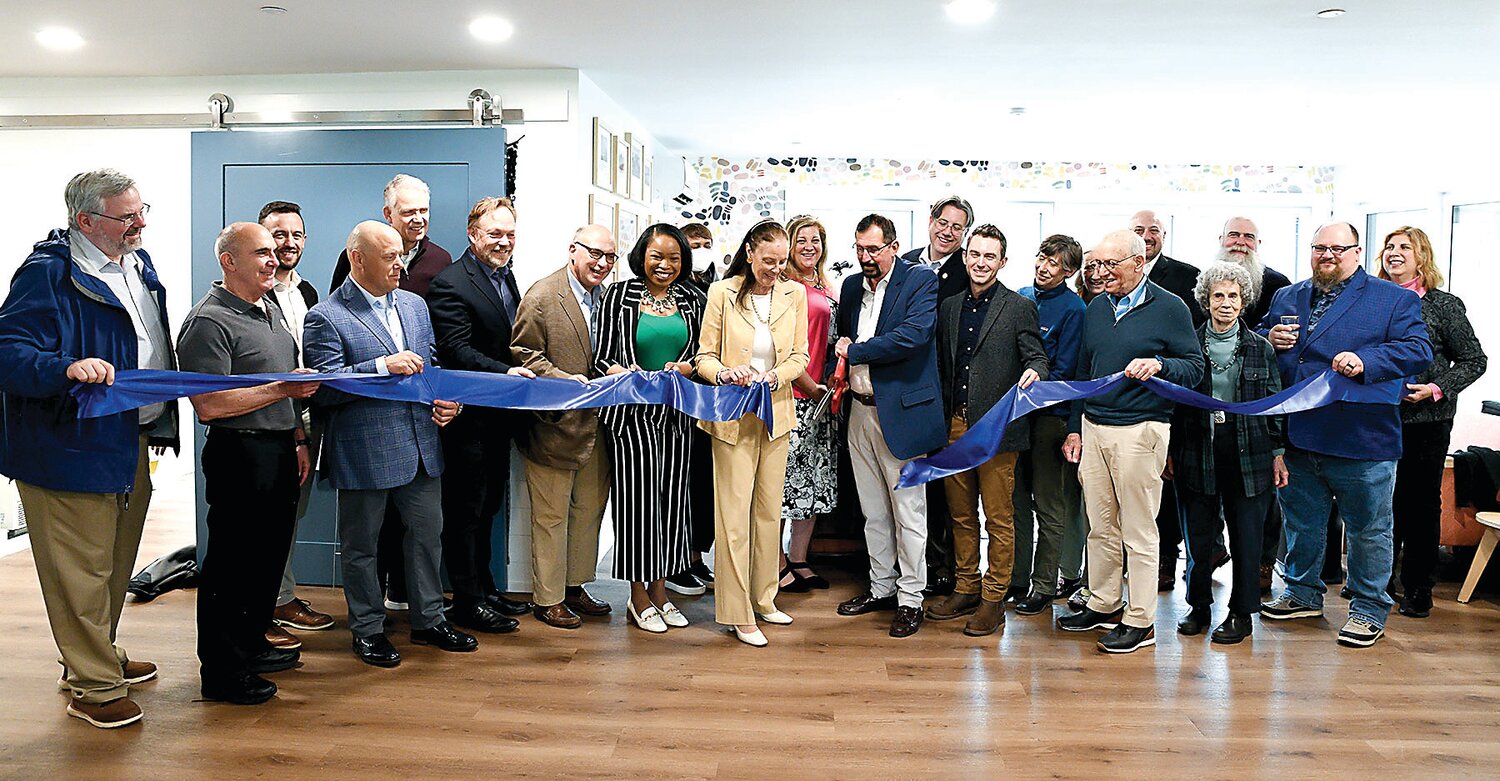 Solebury School Head of School Tom Wilschutz (holding the scissors), board of trustees members, representatives from Metcalfe Architecture & Design, and others involved in the project participate in the ribbon-cutting ceremony for Hope Hall.