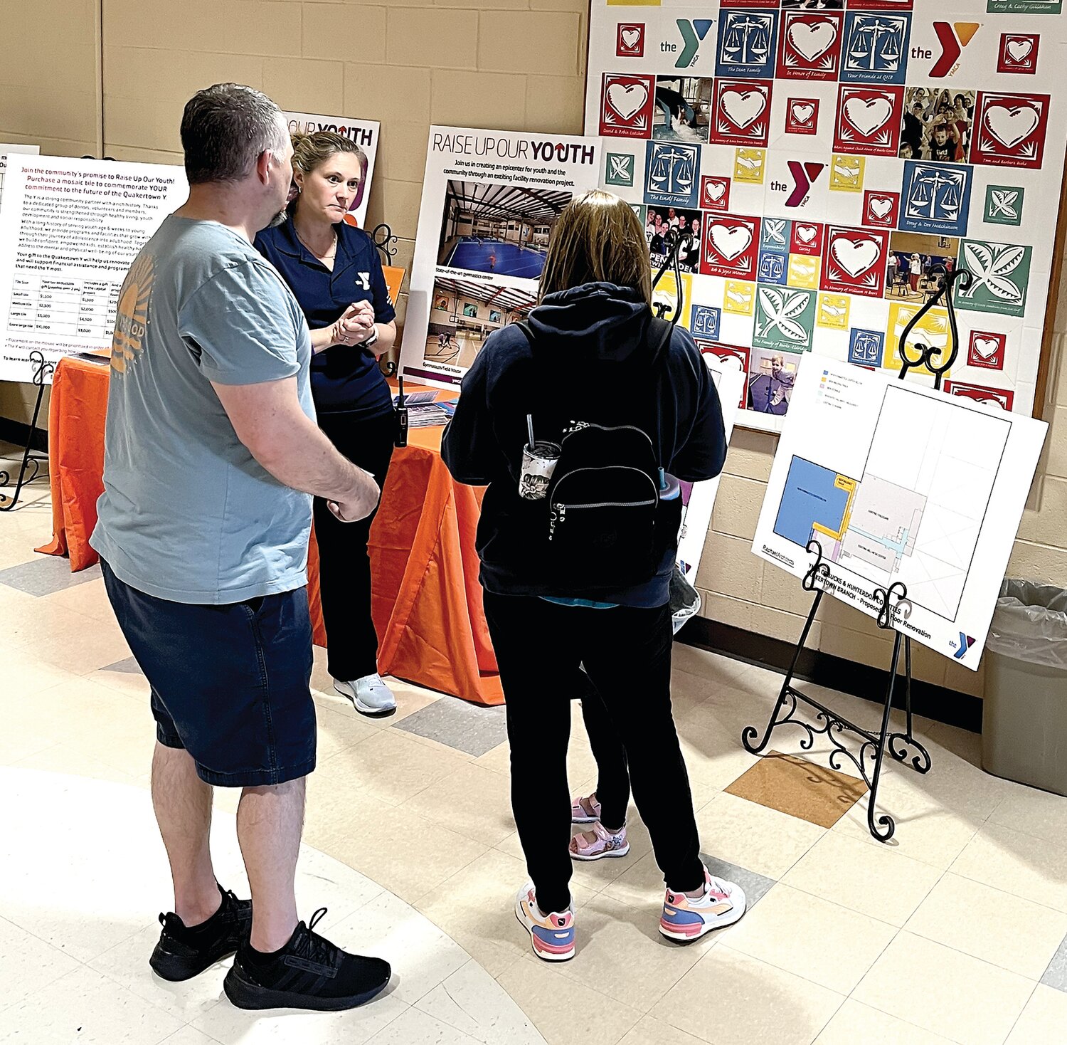 Allyson Fox, vice president of operations for Upper Bucks Region of YMCA of Bucks and Hunterdon Counties, discusses the Raise Up Our Youth campaign with visitors at the Quakertown branch campaign launch on April 26.