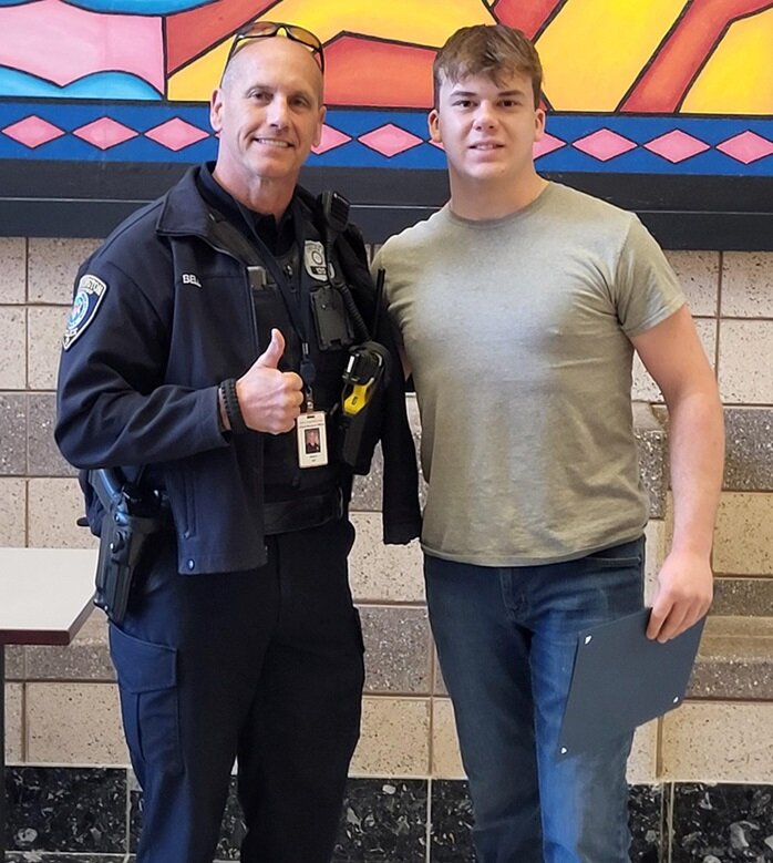 Warrington Township Police Officer and Central Bucks South High School Resource Officer Robert Bell congratulates Ben Schubert for his quick actions at scene of car crash.