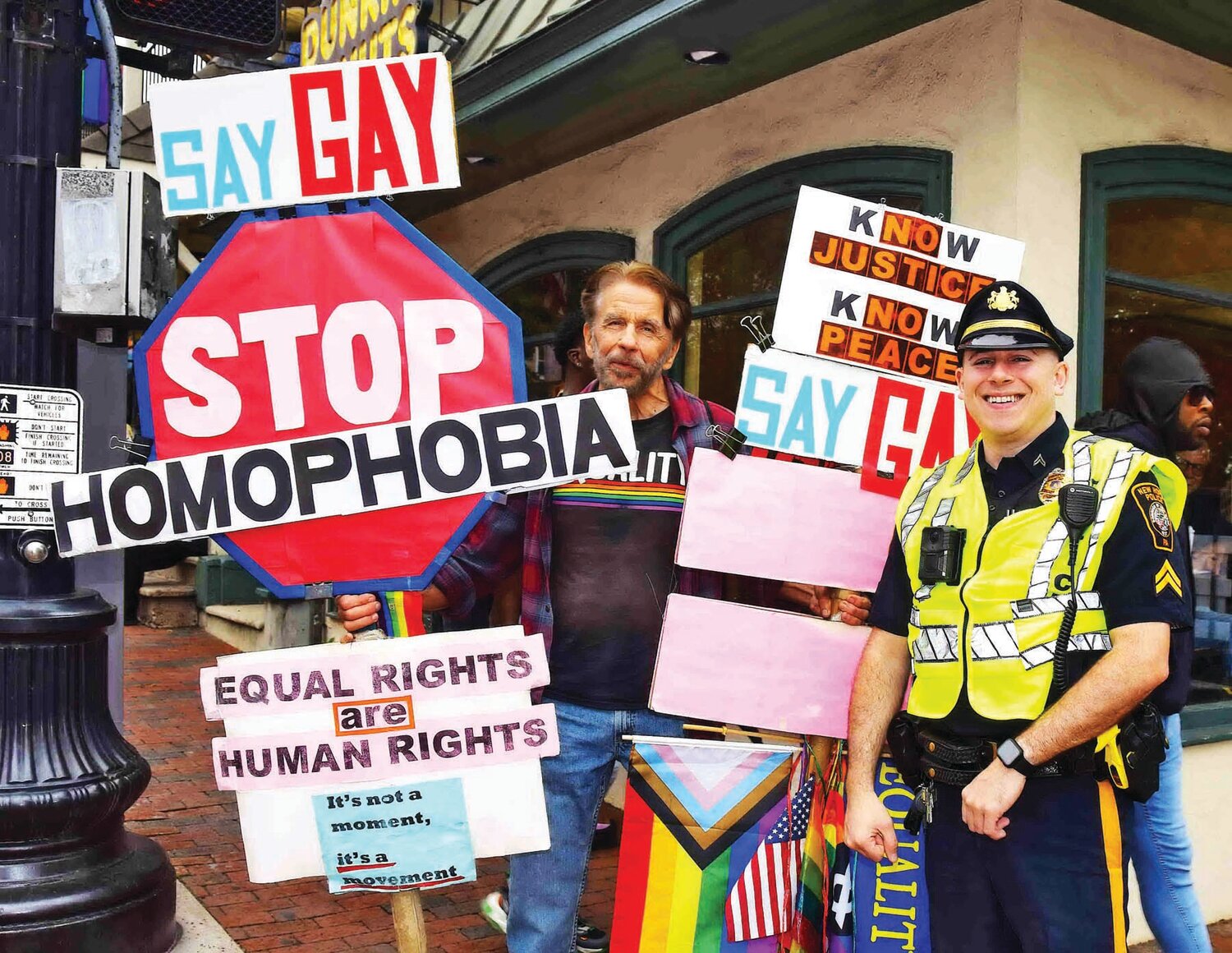 A police officer and a Pride Parade spectator stand on the corner of Main Street in New Hope.