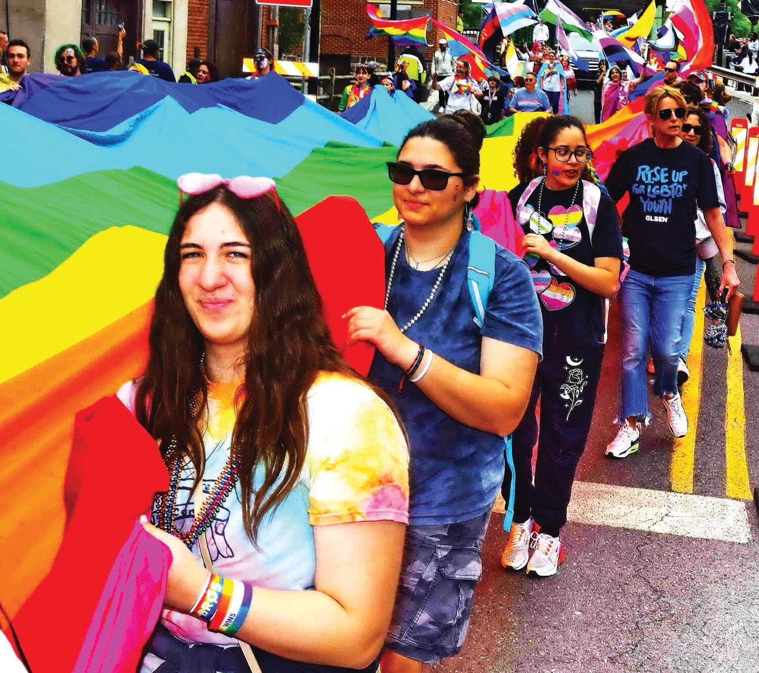 Pride Parade participants carry New Hope Celebrates’ 100-foot rainbow flag along the parade route.