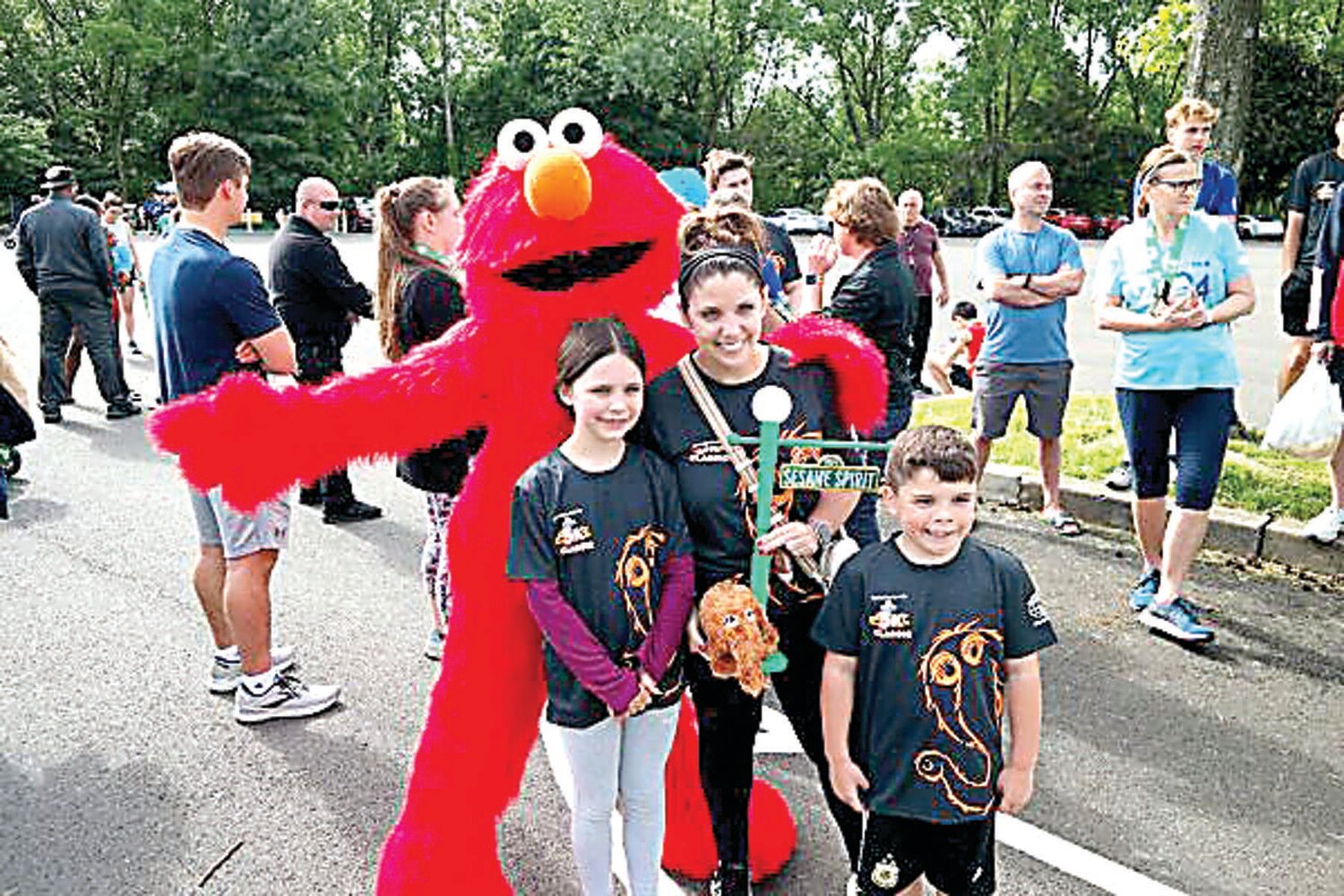 The Herbert Hoover School PTO (Langhorne) receives the annual Spirit Trophy for having the largest runner contingent at Sunday’s Kiwanis-Herald Sesame Place Classic. Celebrating with Sesame character Elmo are Megan Tondi and youngsters Violet and Vincent Tondi.