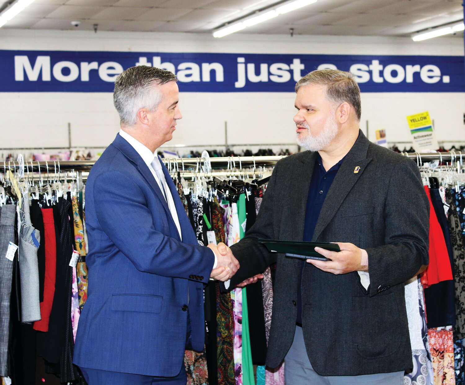Bucks County Commissioner Robert Harvie, left, and Goodwill Keystone Area President and CEO Ed Lada shake hands inside the store.