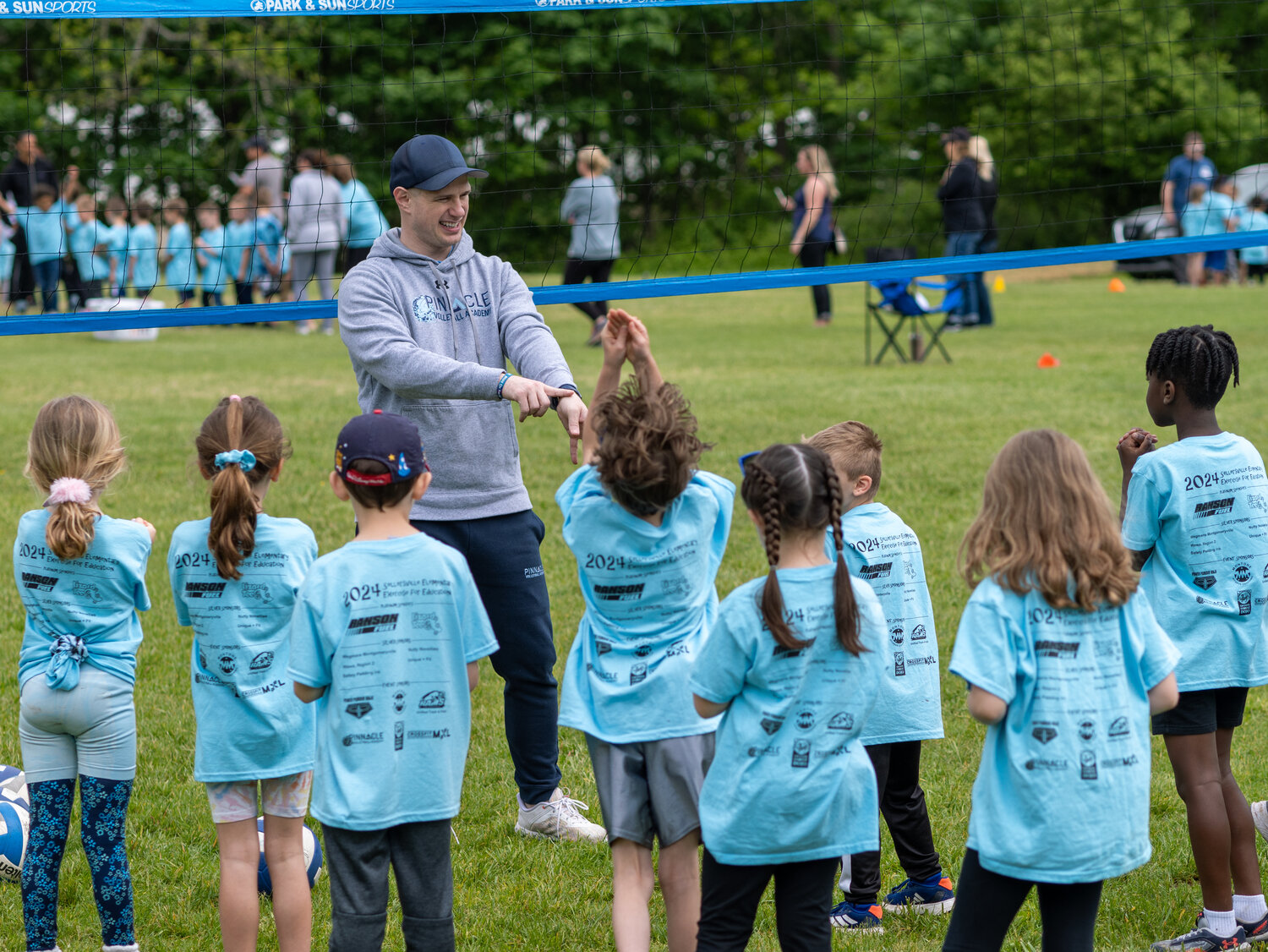 Pinnacle Volleyball Academy Director Brandon Johnson shows Sellersville Elementary School students what part of the hand to use to strike the volleyball. Johnson was a four-year-starter on the Pennridge High School Volleyball team when he was a student.