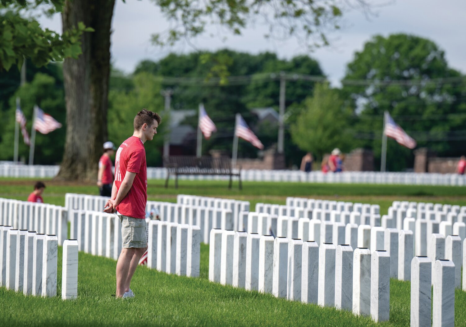 A volunteer who participated in The Honor Project pays his respect to service members buried at Washington Crossing National Cemetery.