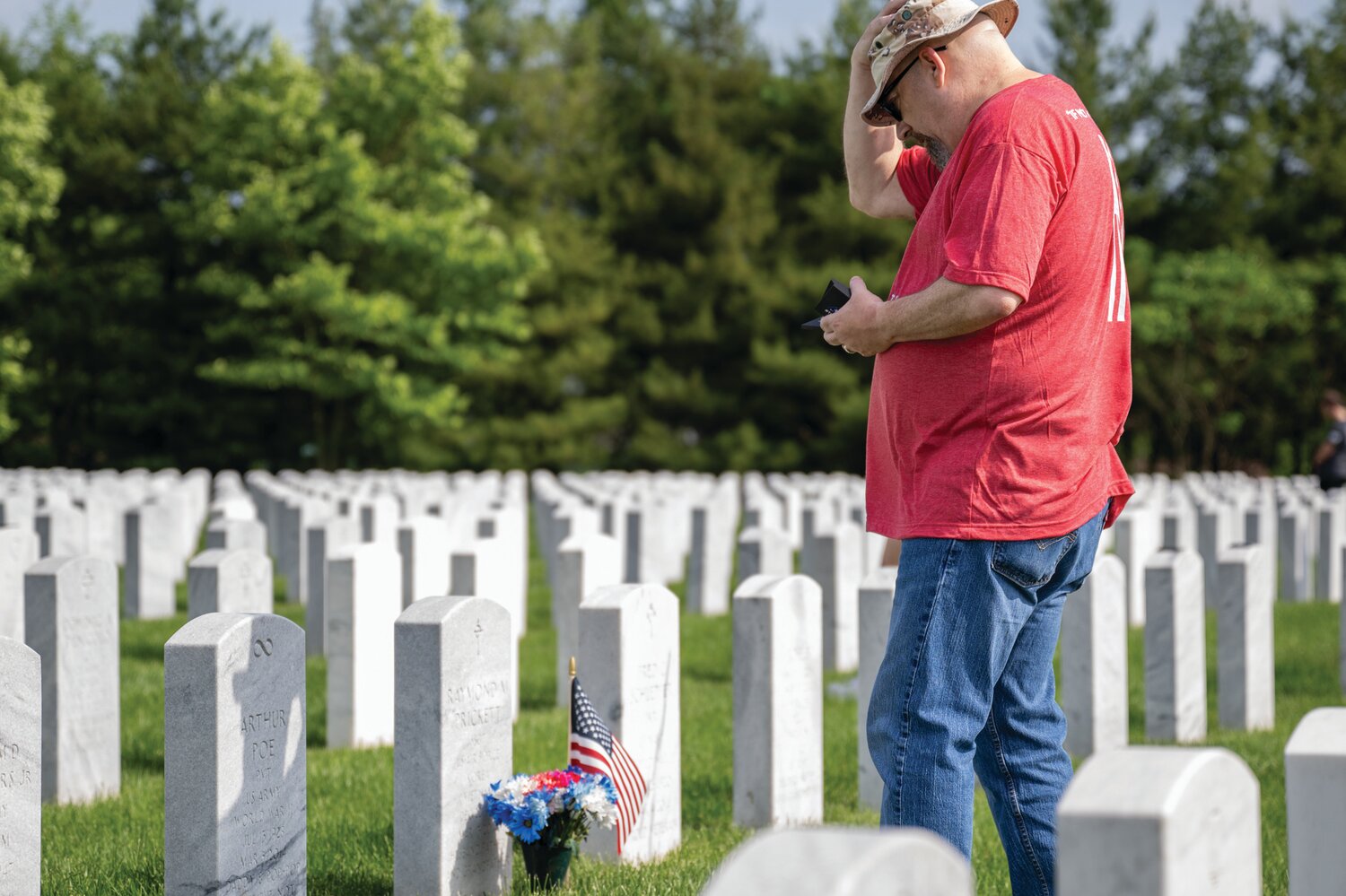 A volunteer pauses at a gravestone in Washington Crossing National Cemetery.