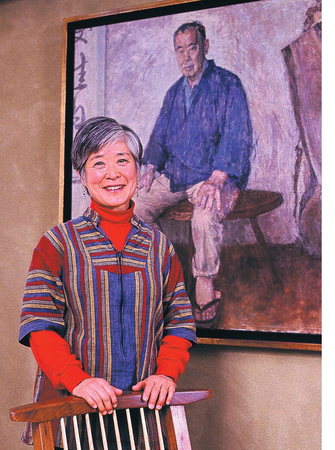 Mira Nakashima stands in front of a portrait of her father, George, at the Michener Art Museum in Doylestown.