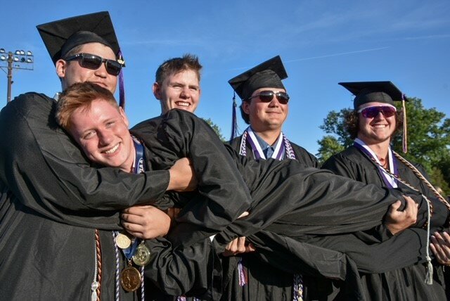 (From left) Gavin Lee, Alexander Riexinger, Troy Macik and Kyle Kirsch give Trevor Johnson a lift after the graduation ceremony.