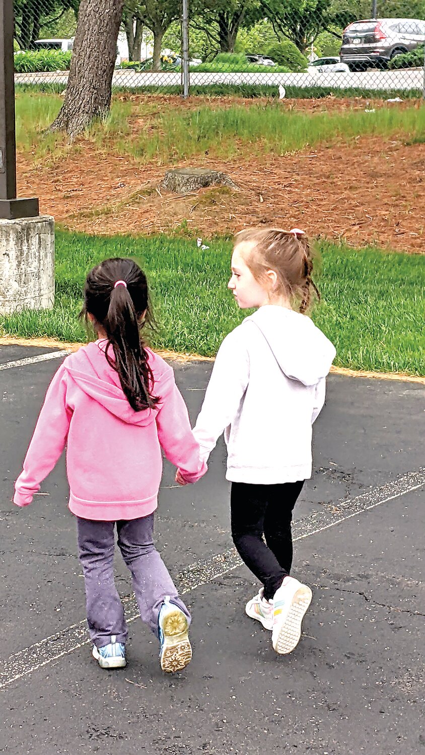 A pair of Woodside Christian Preschool students hold hands while participating in the school’s Walk A Thon.