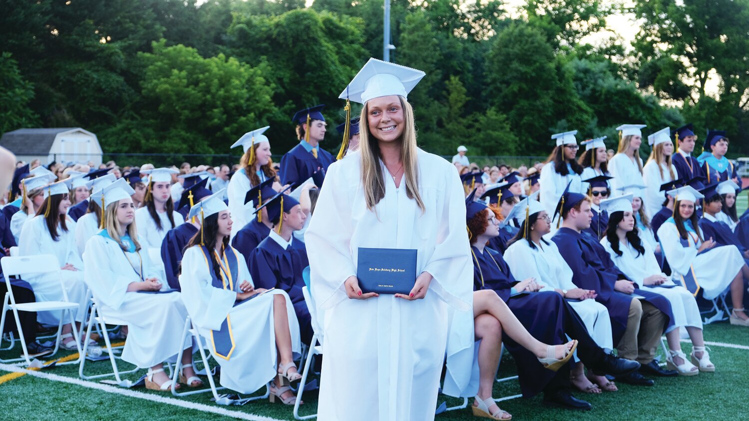 A member of New Hope-Solebury’s Class of 2024 holds up her diploma.