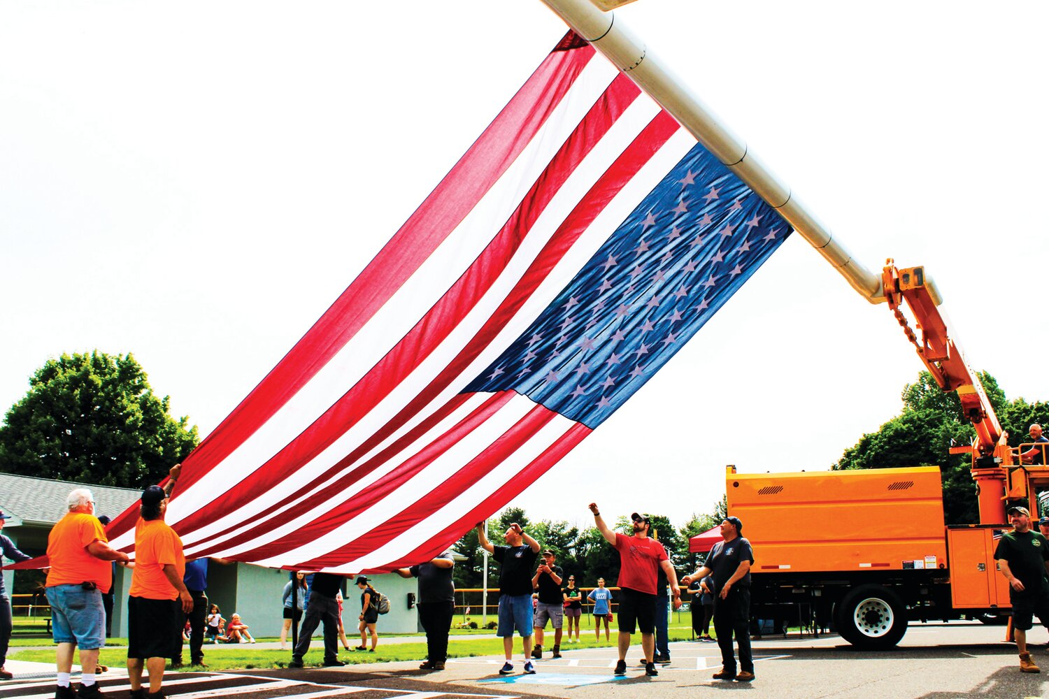 An American flag, provided by ATS Tree Services, that hung during a tree planting event at Hilltown Civic Park is lowered in preparation for a formal flag folding ceremony.