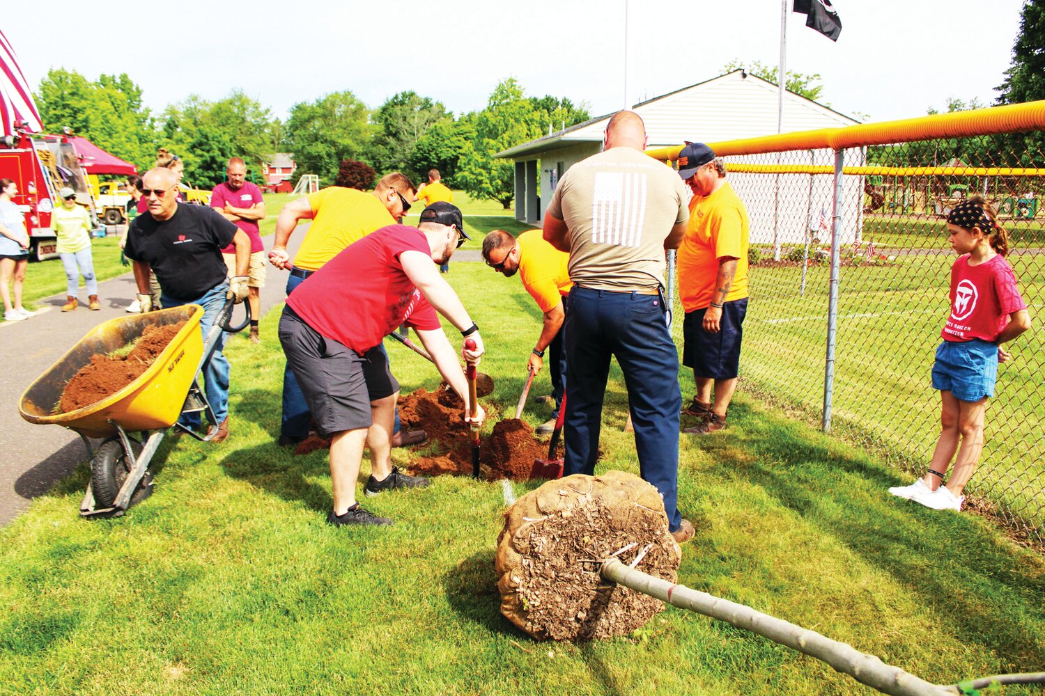 Volunteers dig a hole for one of five trees that were planted in Hilltown Civic Park.