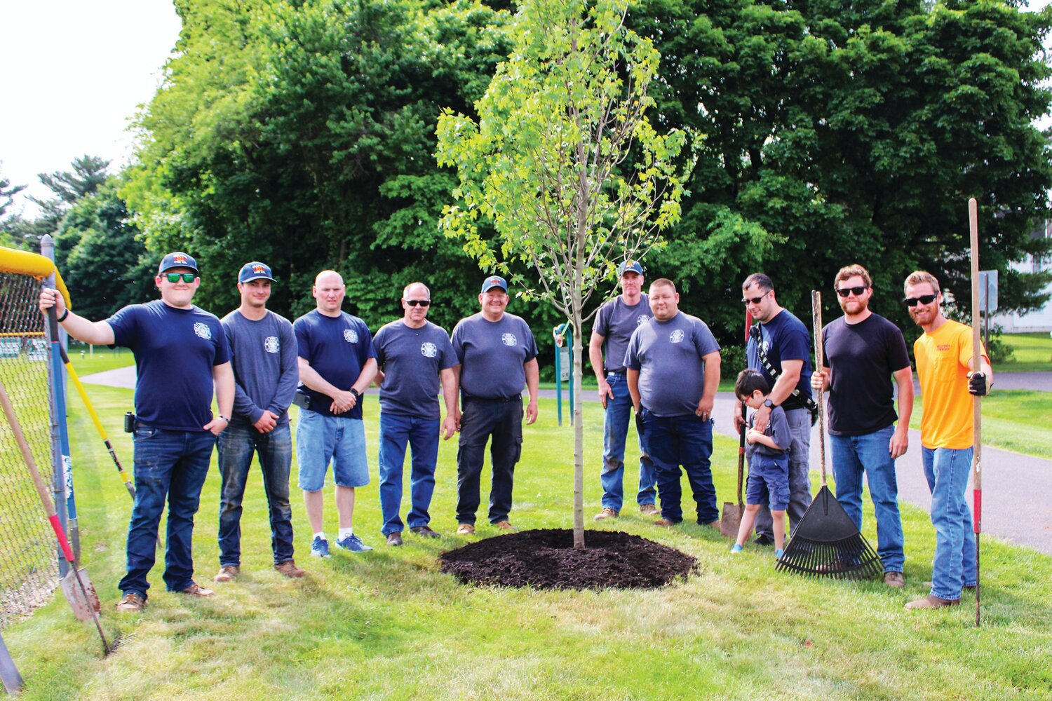 Volunteers gather around one of the trees planted in Hilltown Civic Park. The tree-planting event was hosted by Hilltown Township Public Works and the Travis Manion Foundation and participants included 20 members of the Hilltown Township Volunteer Fire Company.