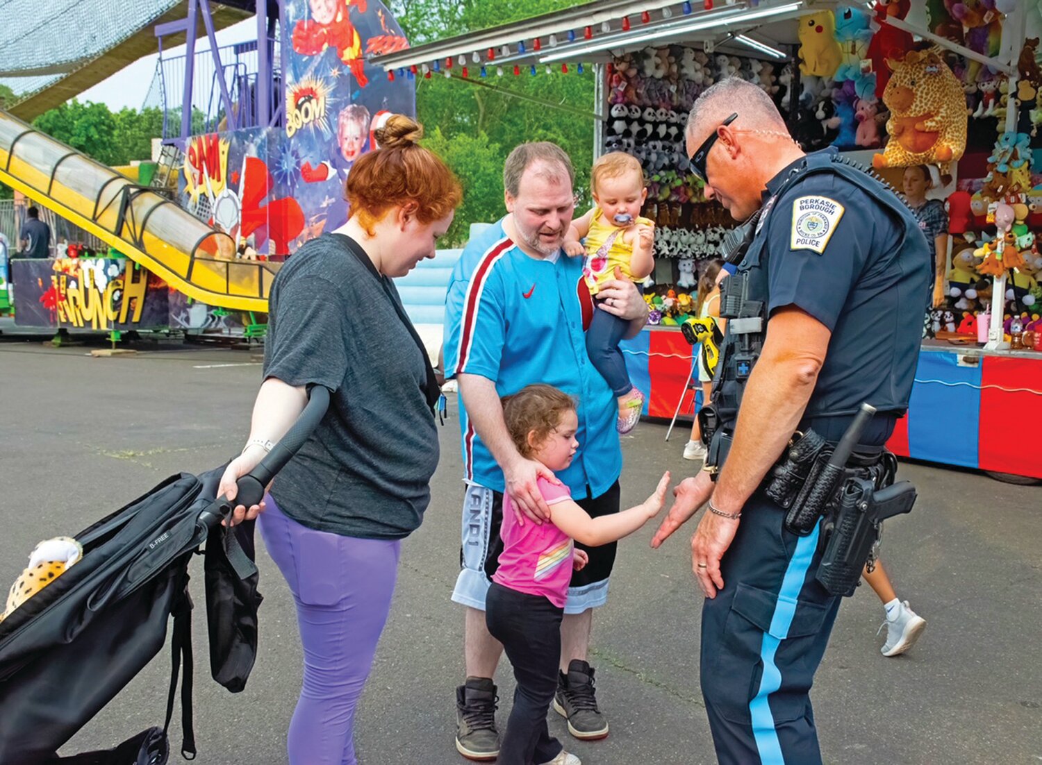 Nora Romano gives a high five to Perkasie Borough Police Officer Tom Brun as her family members, Nick, Sheila and Harper, look on.