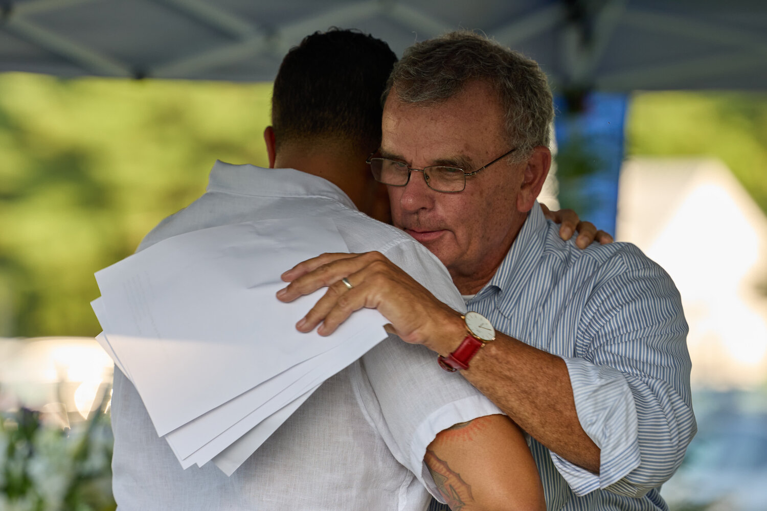 Paul Sheils, who lost his grandchildren Matilda and Conrad, in last summer’s deadly flash flood is embraced by The Crossing lead pastor George Matthew Clash.