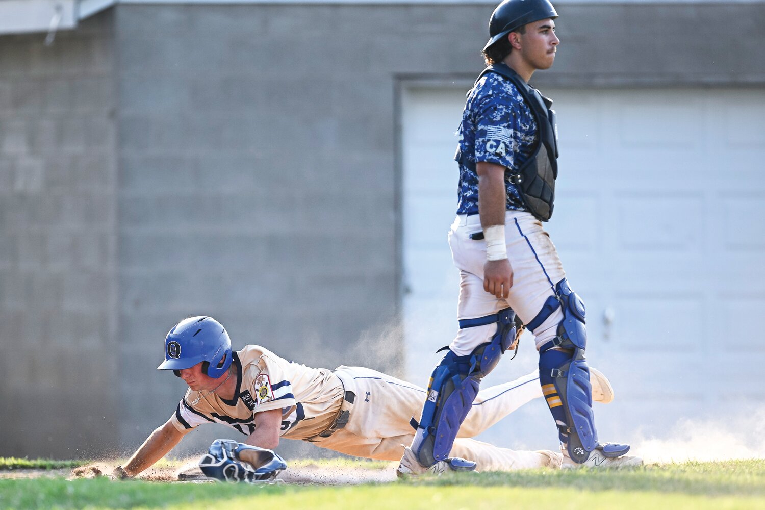 Quakertown’s Carver Perrone slides in safely after a wild pitch in the fifth inning, making the score 4-2.