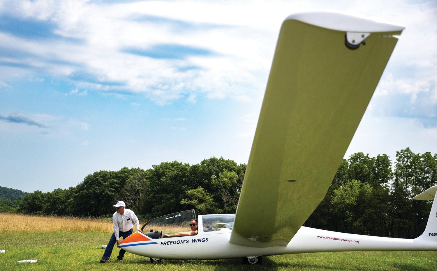 On a hot, steamy Sunday afternoon, President of Freedom’s Wings International Gil Frost helps move a sailplane into position for takeoff at Van Sant Airport in Tinicum.