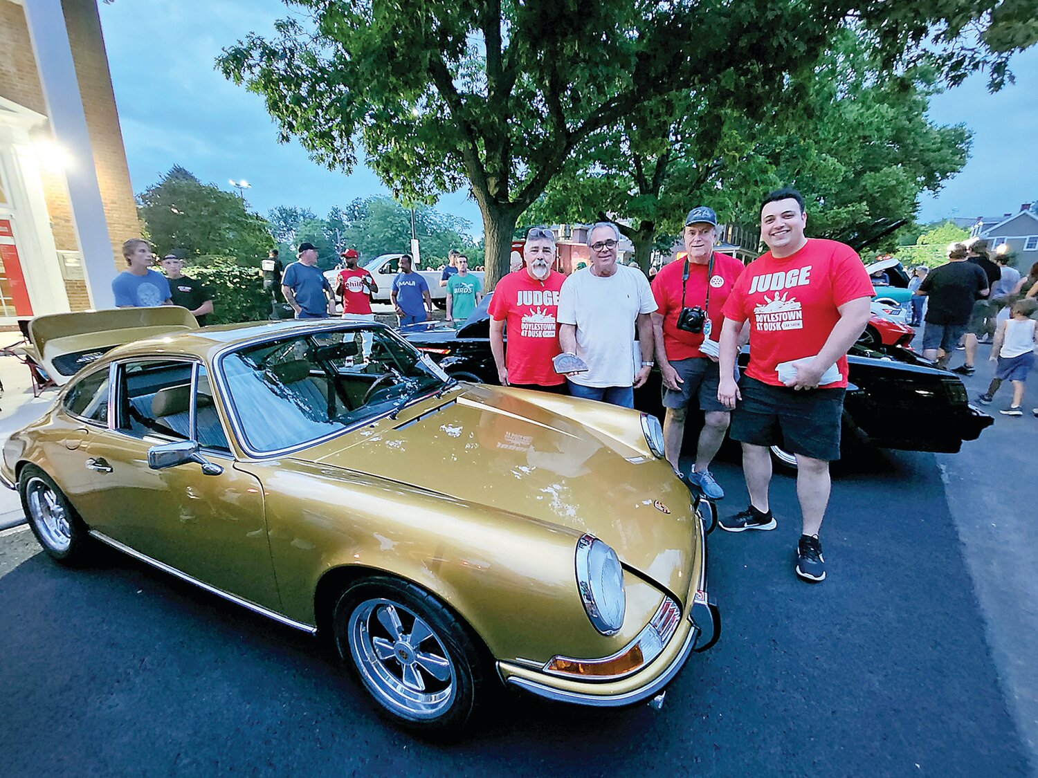 Victor Morgado, one of the Top 40 winners for his 1972 Porsche 911 T, stands with the judges.