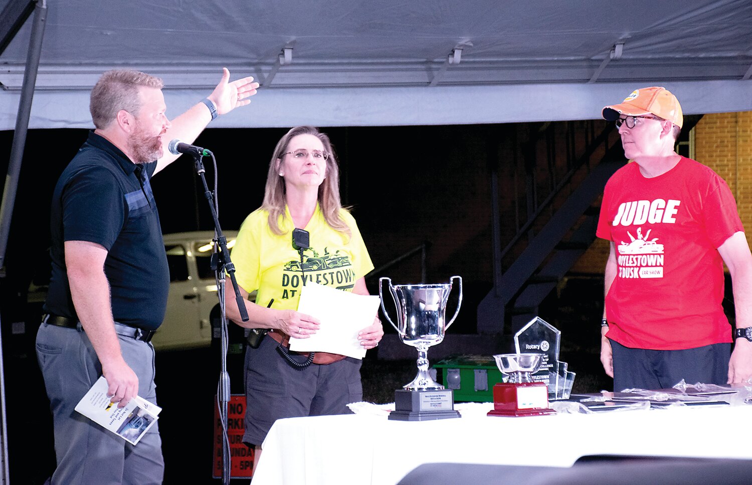 Jordan Meserole, emcee; Helen Amelsberg, car show chair; and Rick Millham Jr., car show vice chair; announce the special winners.