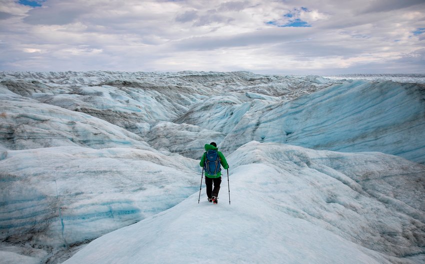 Adam Lyberth maneuvers his way around blue-and-white hills of  ice and snow on the Greenland ice sheet on Friday, August 13, 2021. An Inuit shaman, he says he&rsquo;s walked on the ice more than 3,000 times, and that it changes every day. Lauren Petracca/Staff