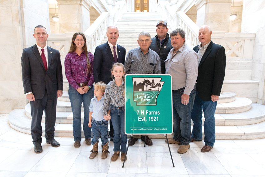 CONTRIBUTED PHOTO The Norton family received a special designation for the family farm being more than 100 years old. Kat and Whitley (front row) Wes Ward, secretary of agriculture, Rachel Norton, Governor Asa Hutchinson, Dennis, Doug and James Norton with Will Norton on the back row.