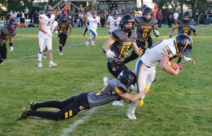 Wolsey-Wessington’s Ashton Hill tries to tackle Castlewood’s Cameron Eng as teammate Cooper Timm (14) pursues on the play during their game Friday in Wolsey.